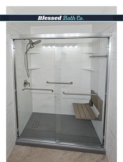 Walk-in shower with a chrome sliding glass door, fold-down seat, grab bars and a dark low-step shower base