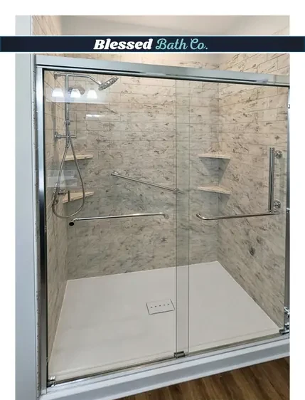 Wide walk-in shower with a chrome sliding glass door and grab bars