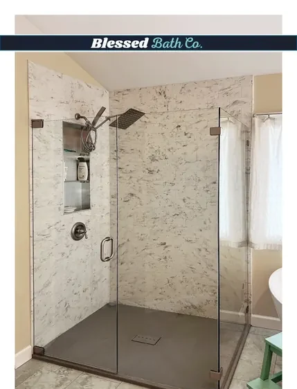 Walk-in shower with stone-look walls, a glass door and a tall recessed niche