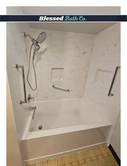 New bathtub and shower combo with marble-look walls, two niches and a handheld showerhead
