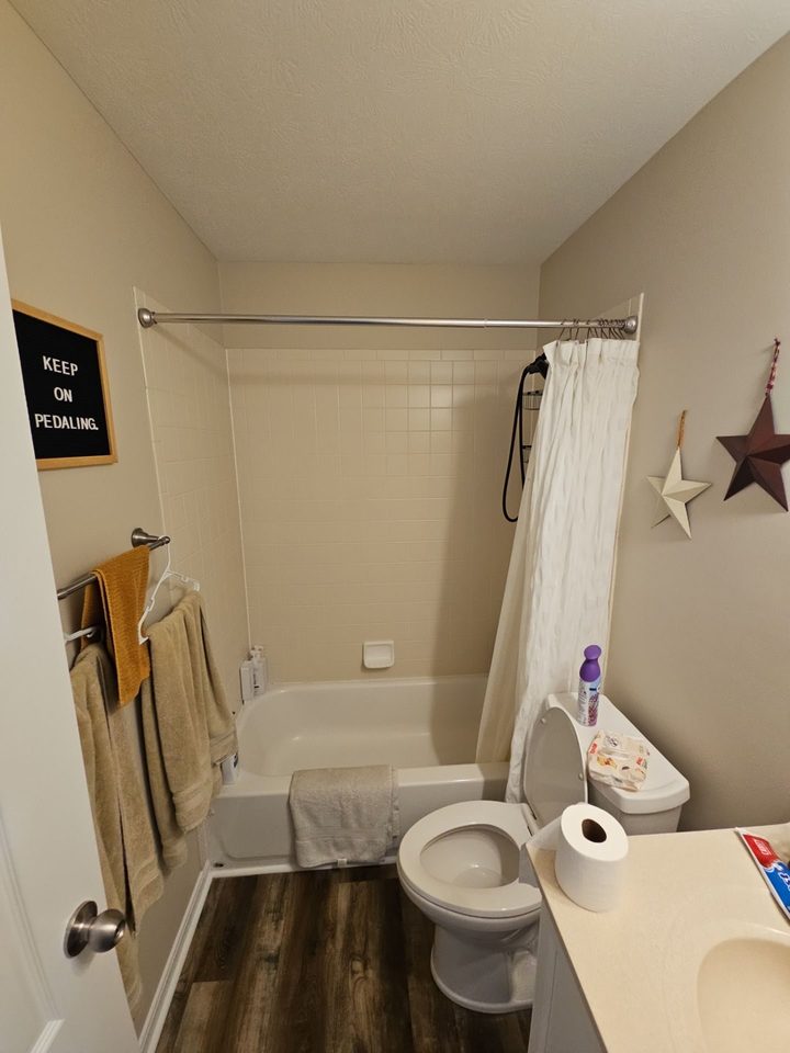 Before: an old white tile tub and shower with a curtain